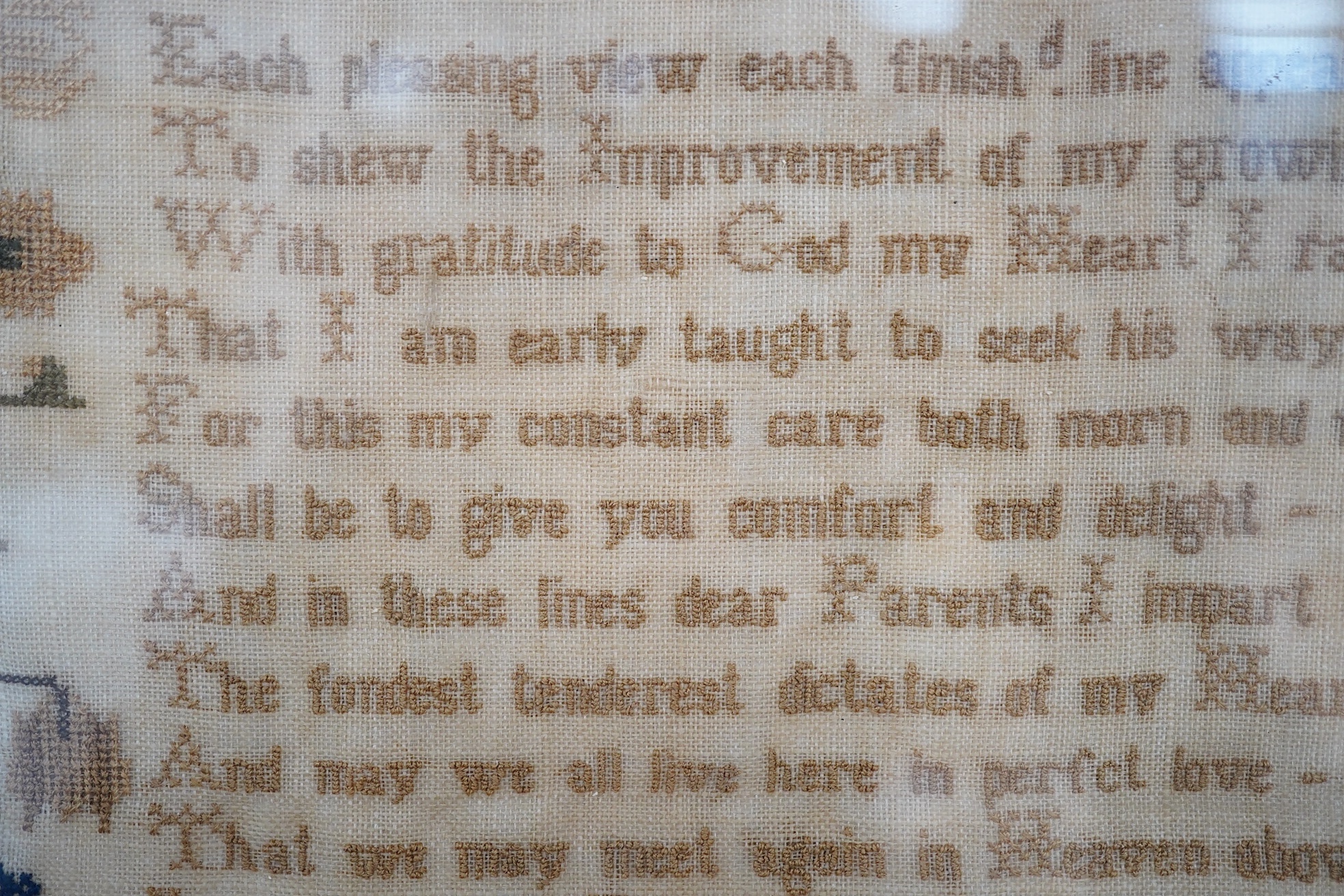 A framed 1835, dated sampler, embroidered by Mary Walker, worked in fine coloured silks, with a central verse and large three storey house, trees, dogs, deer and rabbits, below a panel of embroidered trees, flowers and b